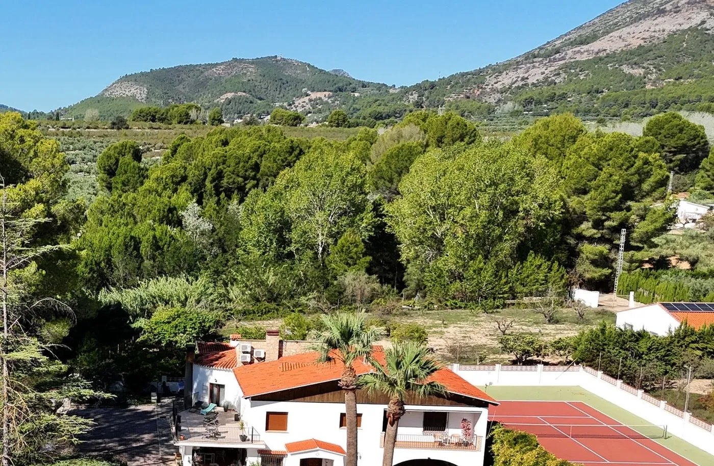Aerial view of La Vida Soñada, the Spanish villa and gardens hosting a women-only, non-sexual naturist retreat, with wooded hills behind